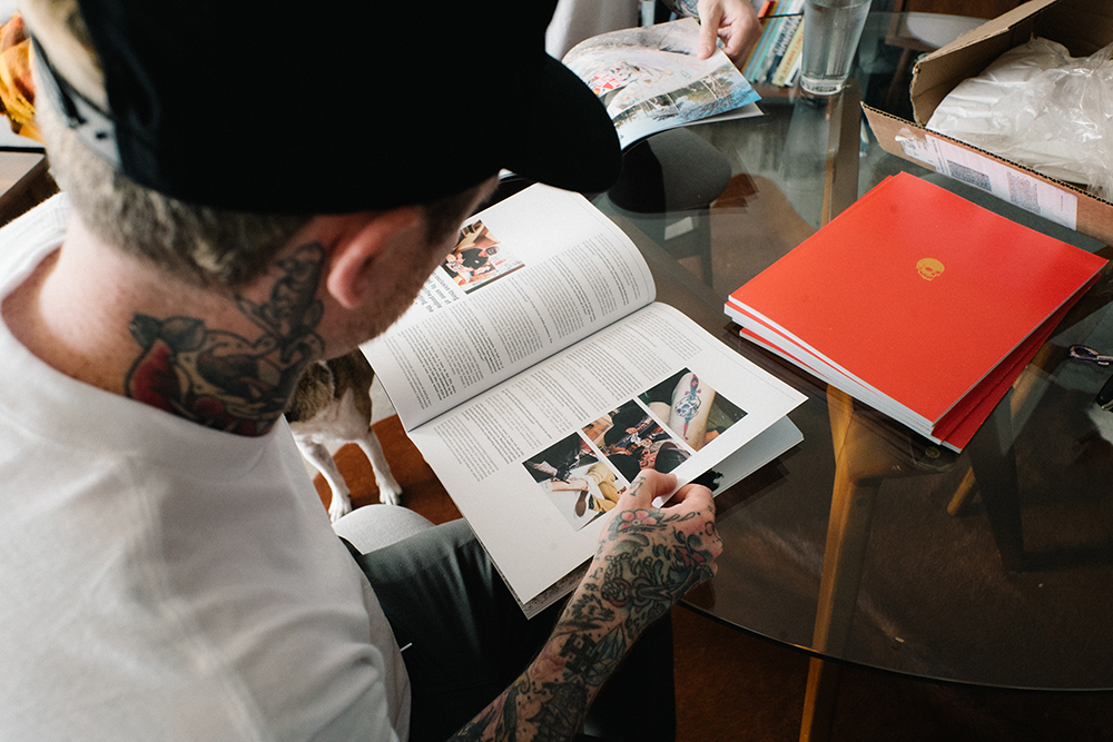 Автор книги о связи татуировки и скейтбординга Бэн и фотограф Энди Экло рассматривают развороты книги